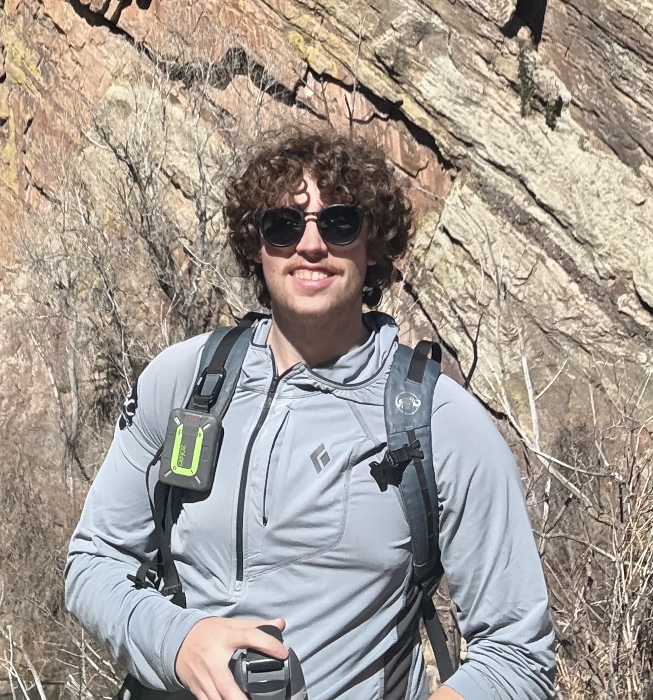 Will Guanci smiling in sunglasses at the crag